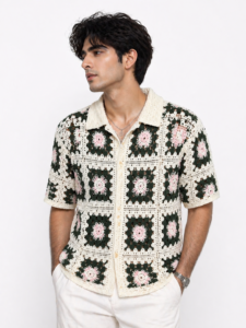 Add a playful, retro vibe to your wardrobe with this Men’s Crochet Granny Square Button-Down Shirt. Featuring a vintage-inspired design, the shirt showcases a unique crochet pattern with pink and green floral accents set against a white backdrop. The classic button-down style and breathable crochet material make this shirt a comfortable choice for warm weather, offering both style and ease. Whether worn for casual outings or relaxed beach days, this shirt adds a pop of color and texture to your look, making it a standout piece in any wardrobe.